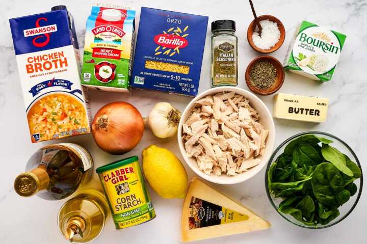 Ingredients for lemon chicken orzo pasta on white marble.