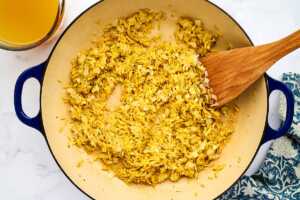 Toasting orzo in a pan.