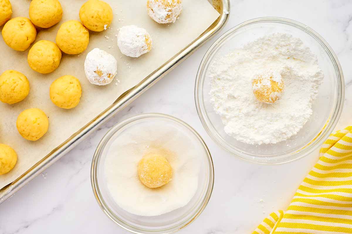 Rolling lemon cookie dough in sugar and powdered sugar.