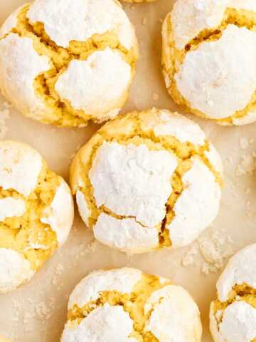 Lemon crinkle cookies on parchment paper.