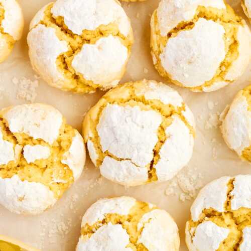 Lemon crinkle cookies on parchment paper.
