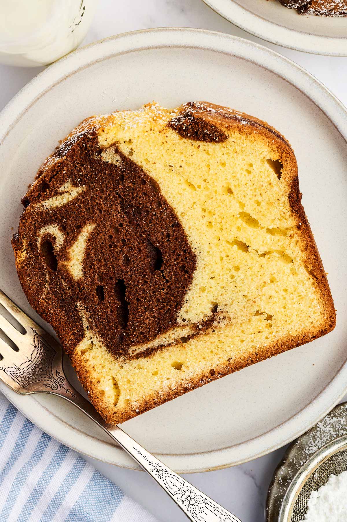 Slice of marble loaf cake on a white plate.