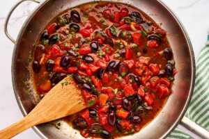Sautéed ingredients for pasta puttanesca in skillet.