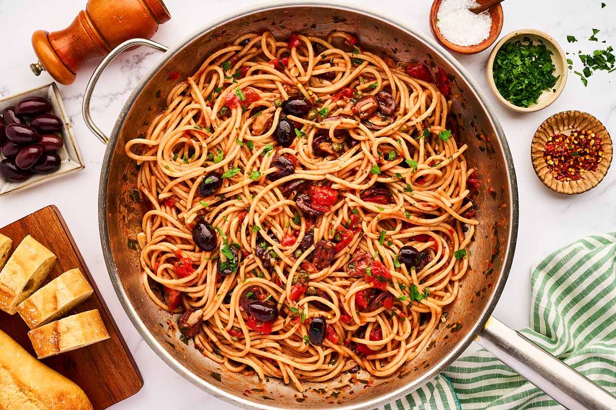 Skillet filled with pasta puttanesca.