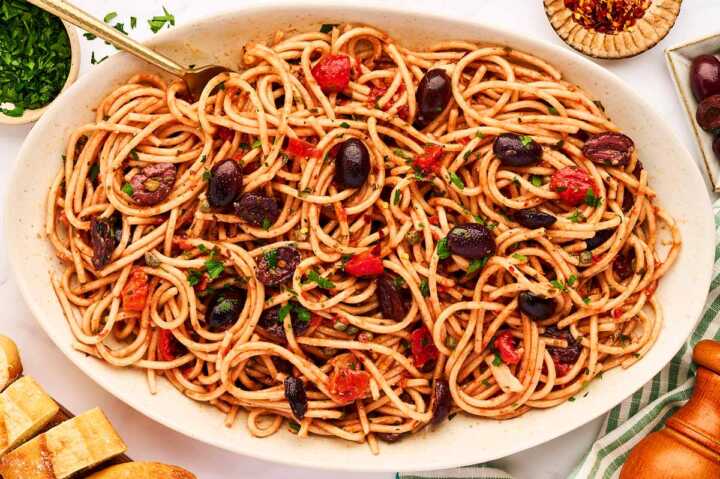 Serving pasta puttanesca on a platter.