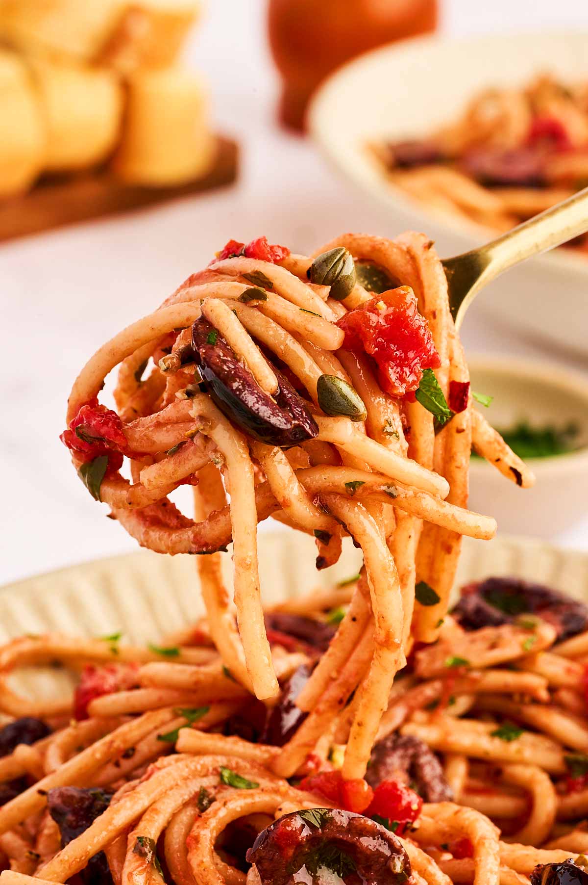 Fork with twirled pasta puttanesca.