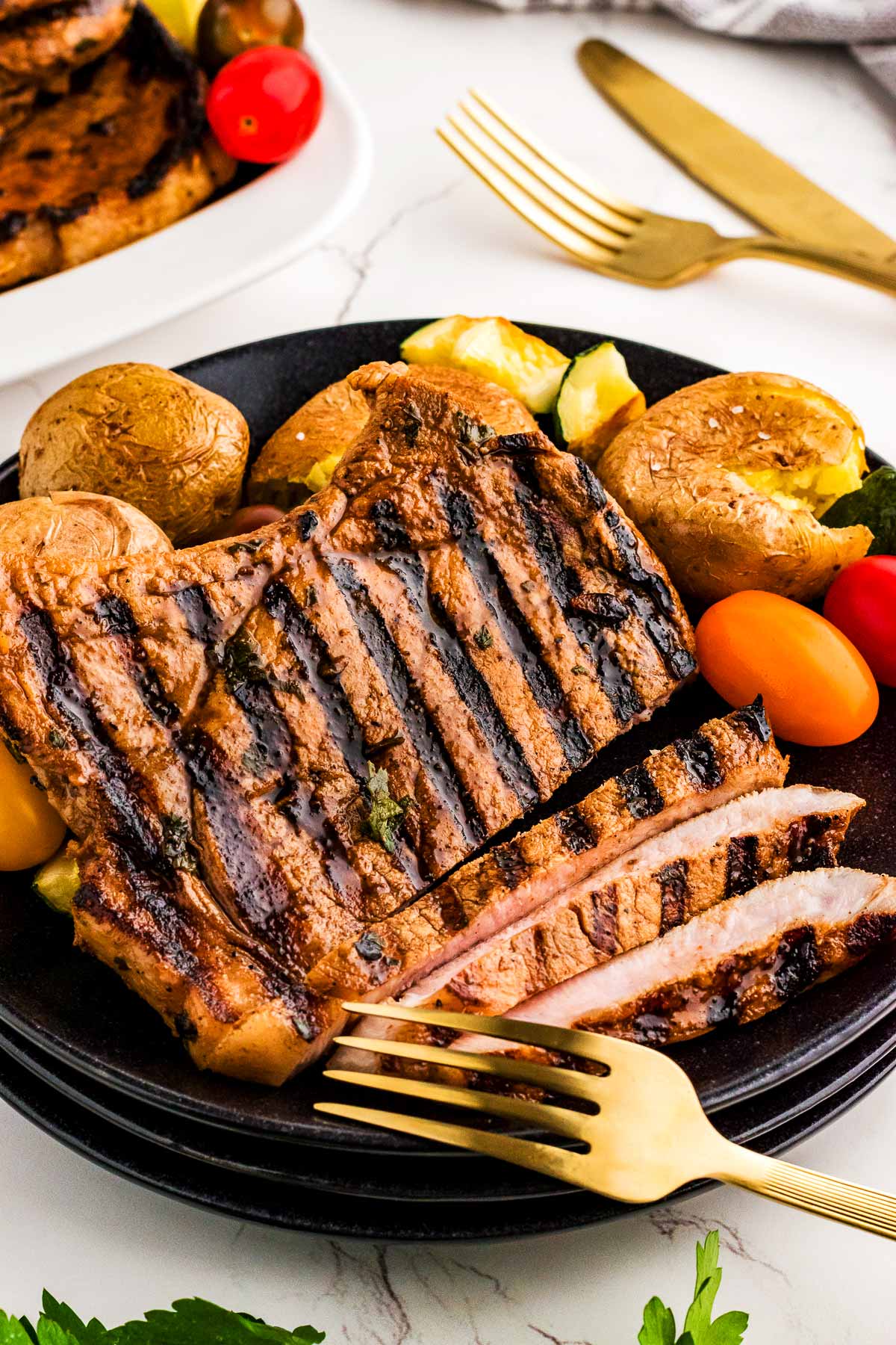 Plate serving pork chops and vegetables.