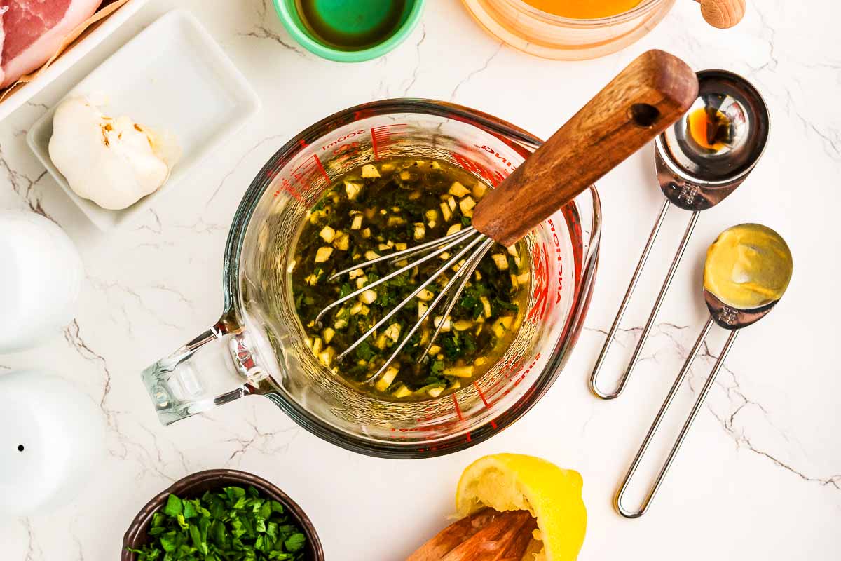 Whisking pork chop marinade in a glass measuring jug.