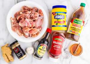 Ingredients for slow cooker honey garlic chicken on a white marble surface.