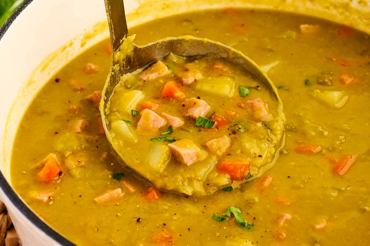 Ladling split pea and ham soup from the pot.