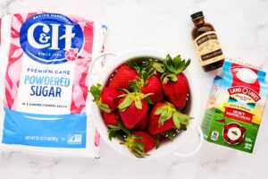 Ingredients for strawberry mousse on white marble.