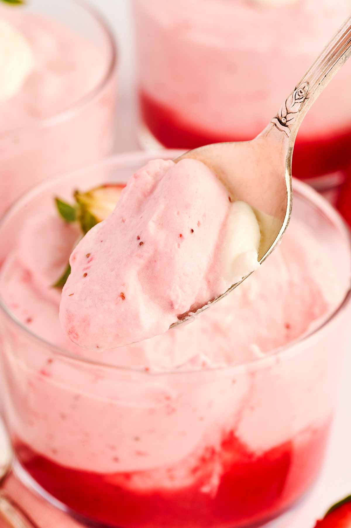 Spoon scooping up strawberry mousse.