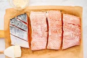 Brushing salmon with mayonnaise.
