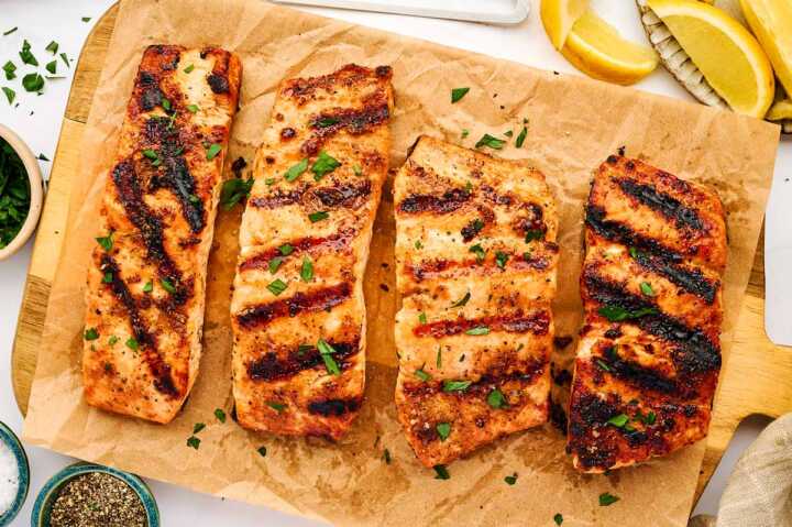 Grilled salmon fillets on parchment paper.
