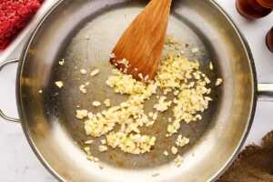 Sautéing aromatics in a skillet.
