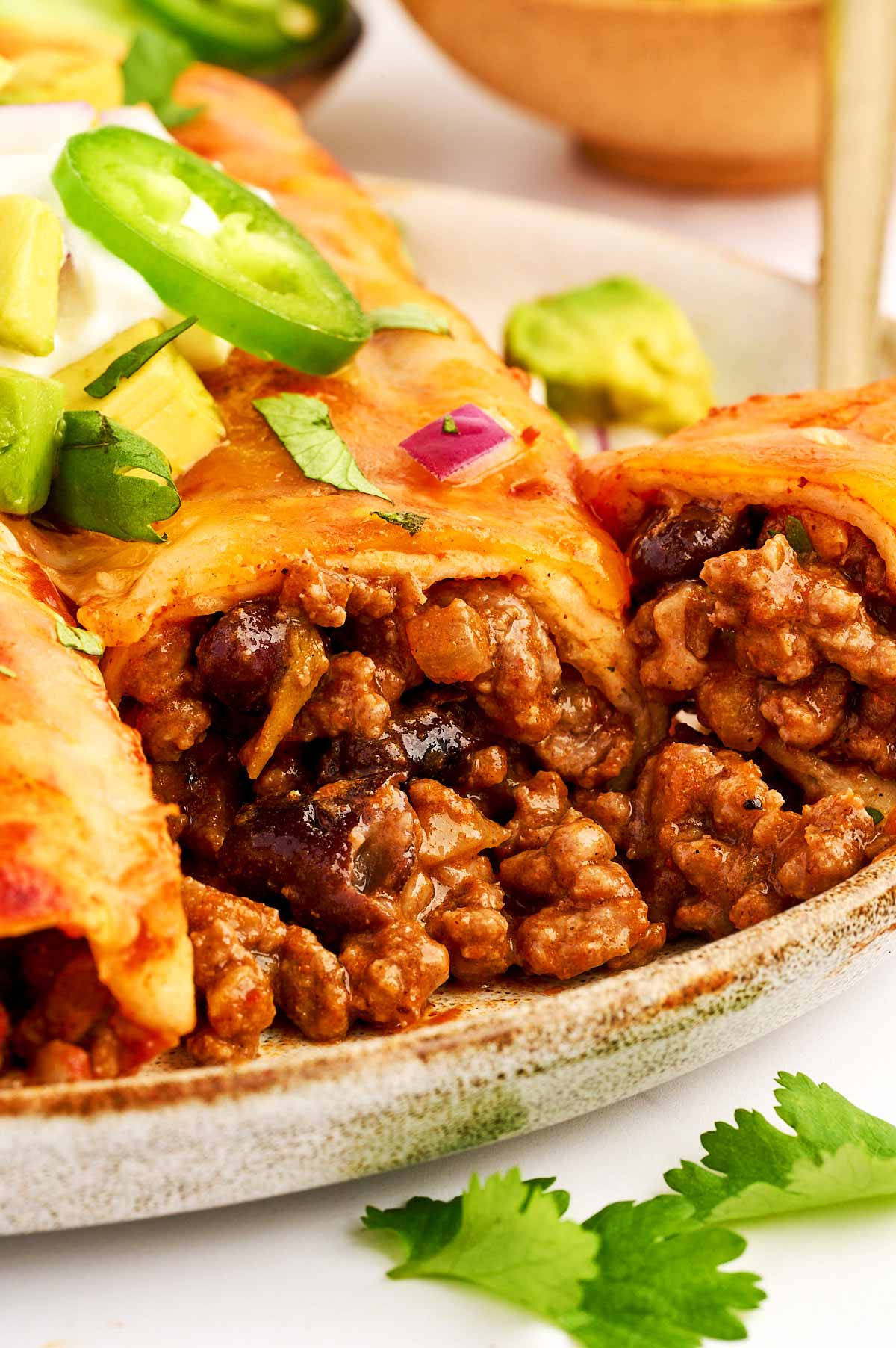 Filling oozing out of a ground beef enchilada.