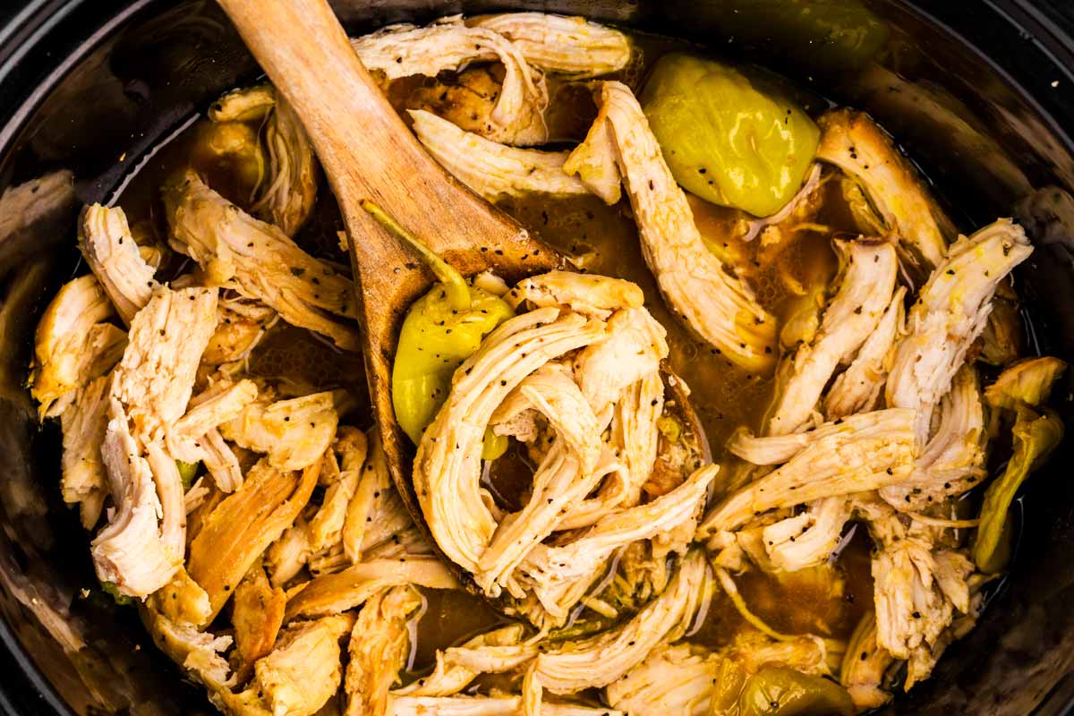Wooden spoon in slow cooker with Mississippi Chicken.