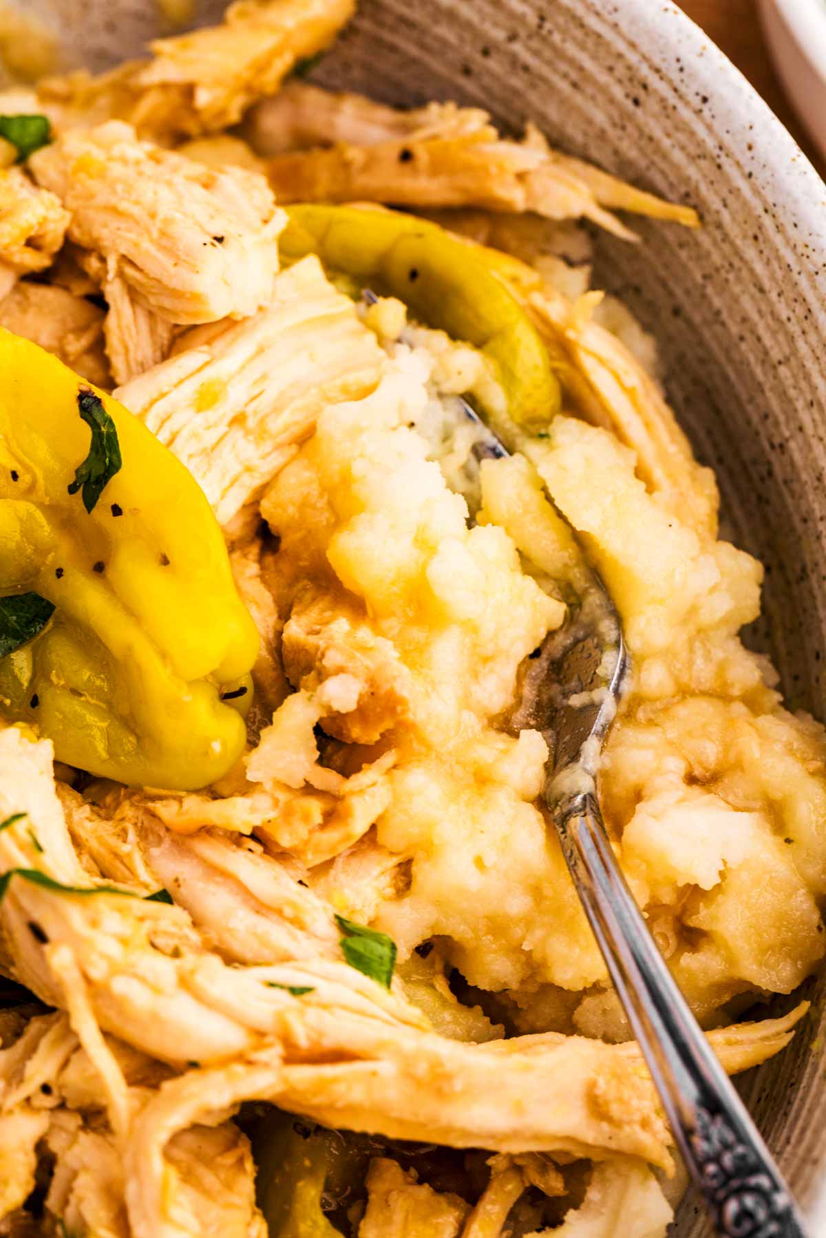 Close up of fork in mashed potatoes with Mississippi Chicken.