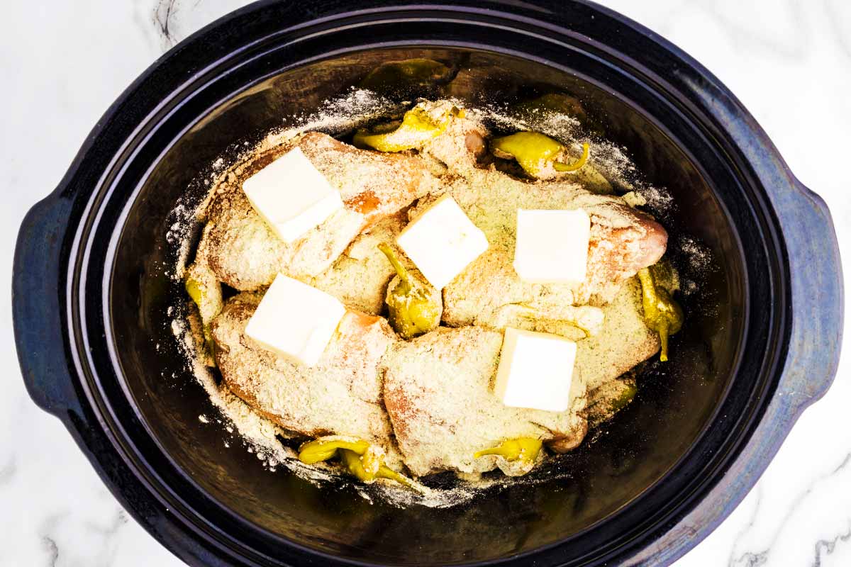 Uncooked Mississippi Chicken in slow cooker.