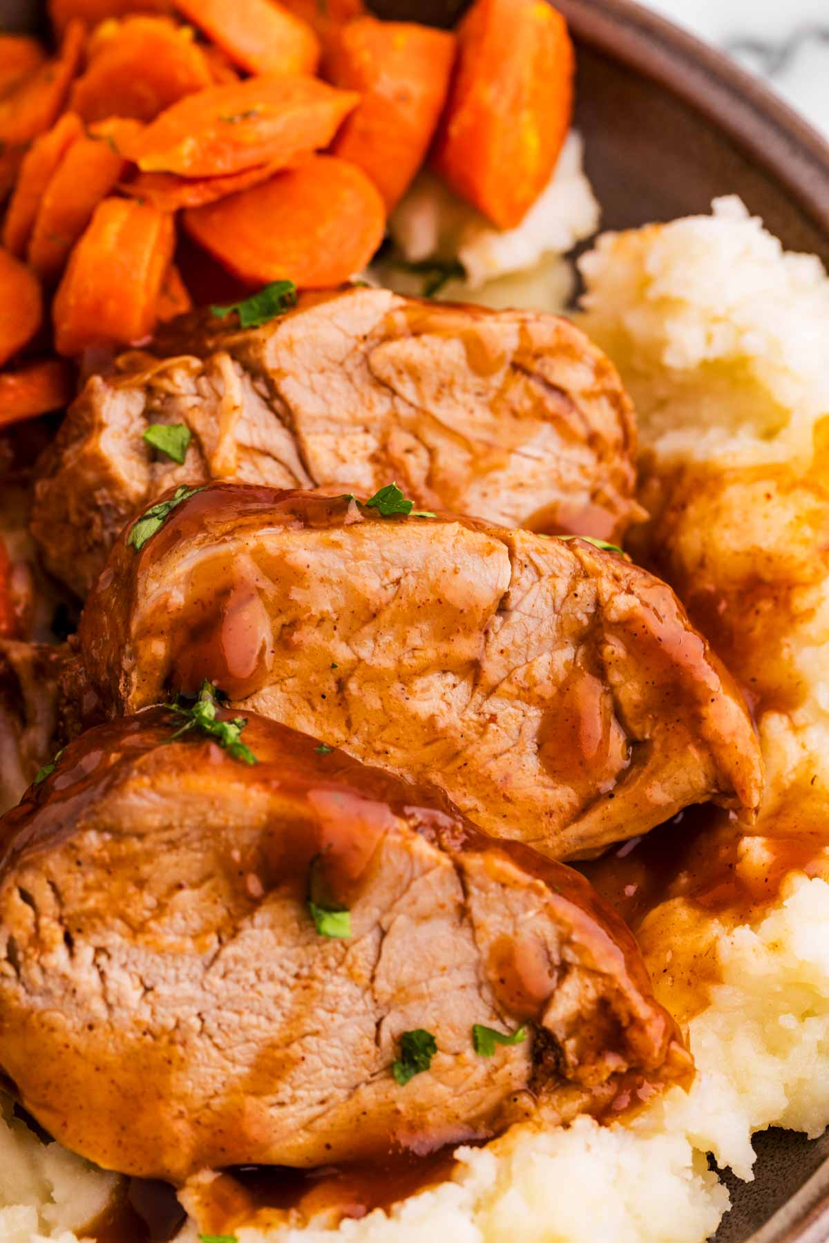 close up shot of sliced pork tenderloin medallions in a bbq balsamic glaze.