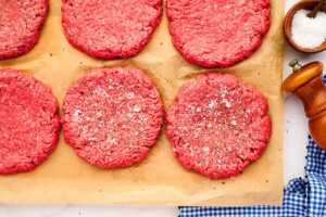 Salted and peppered burger patties.