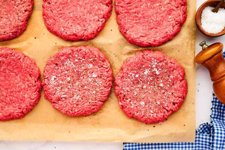 Salted and peppered burger patties.