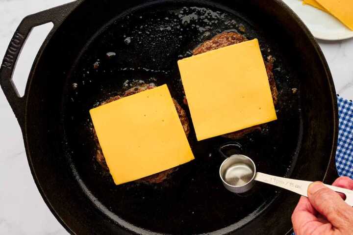 Burger patties topped with cheese.