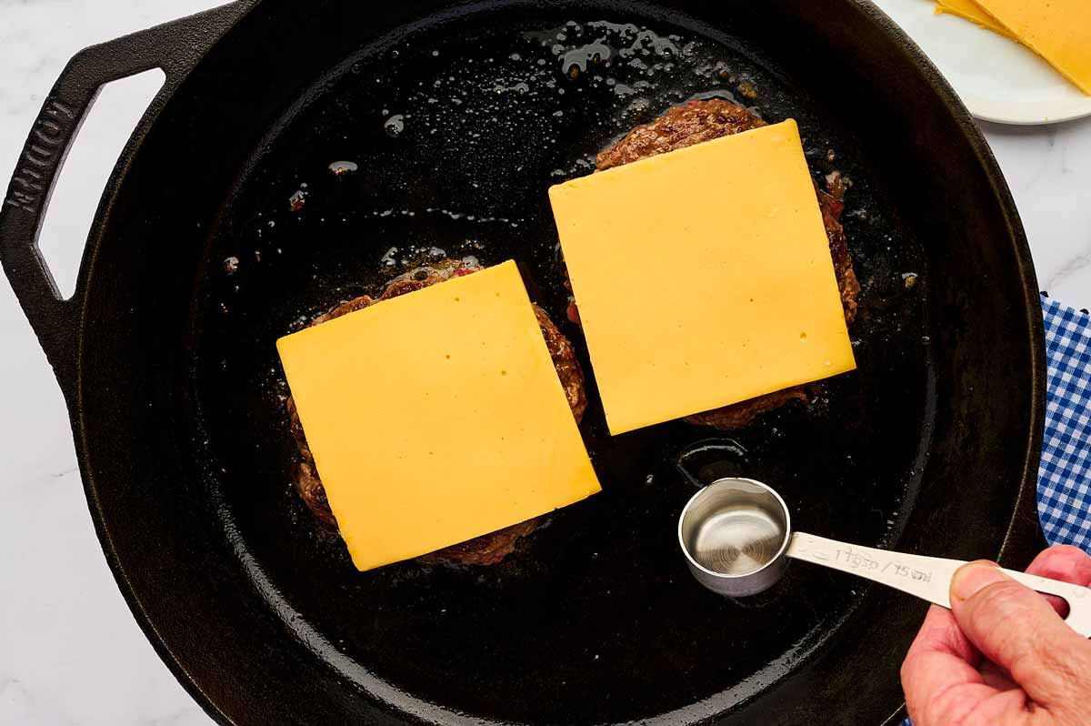 Burger patties topped with cheese.