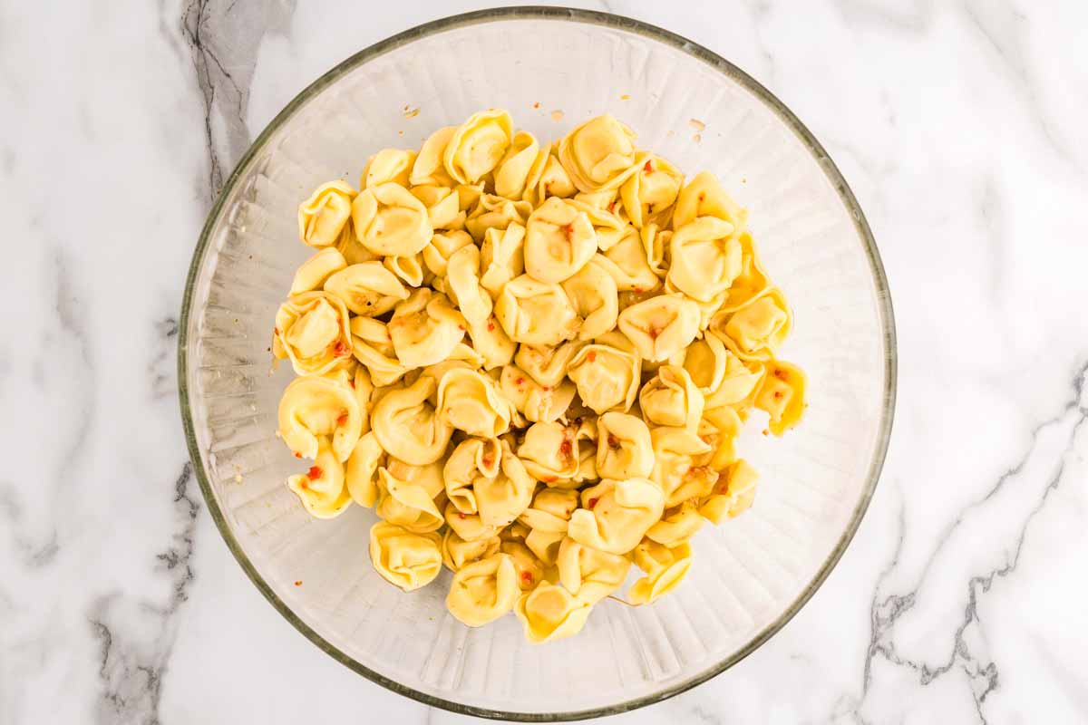 Tortellini sitting in Italian dressing.
