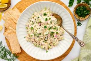 Bowl of tuna salad surrounded by crackers.