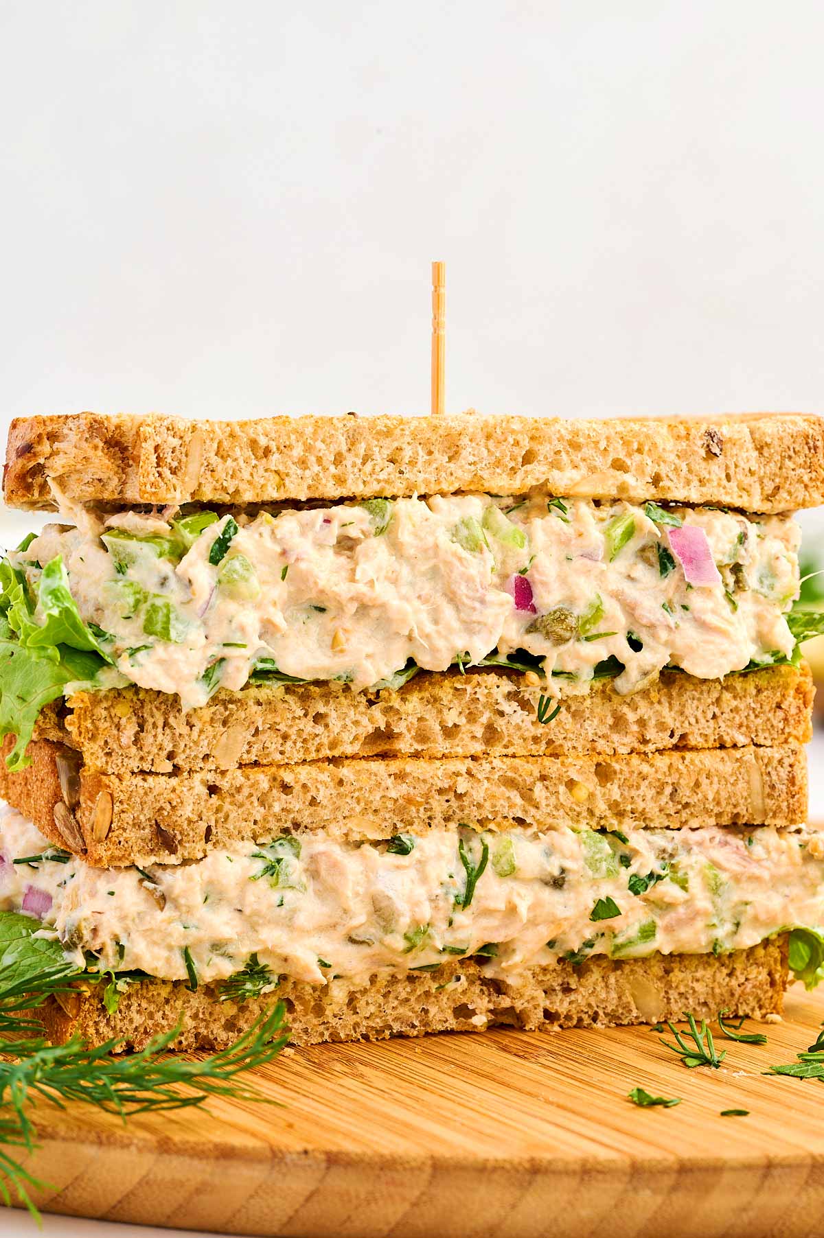 Tuna Salad sandwich stacked on a wooden board.
