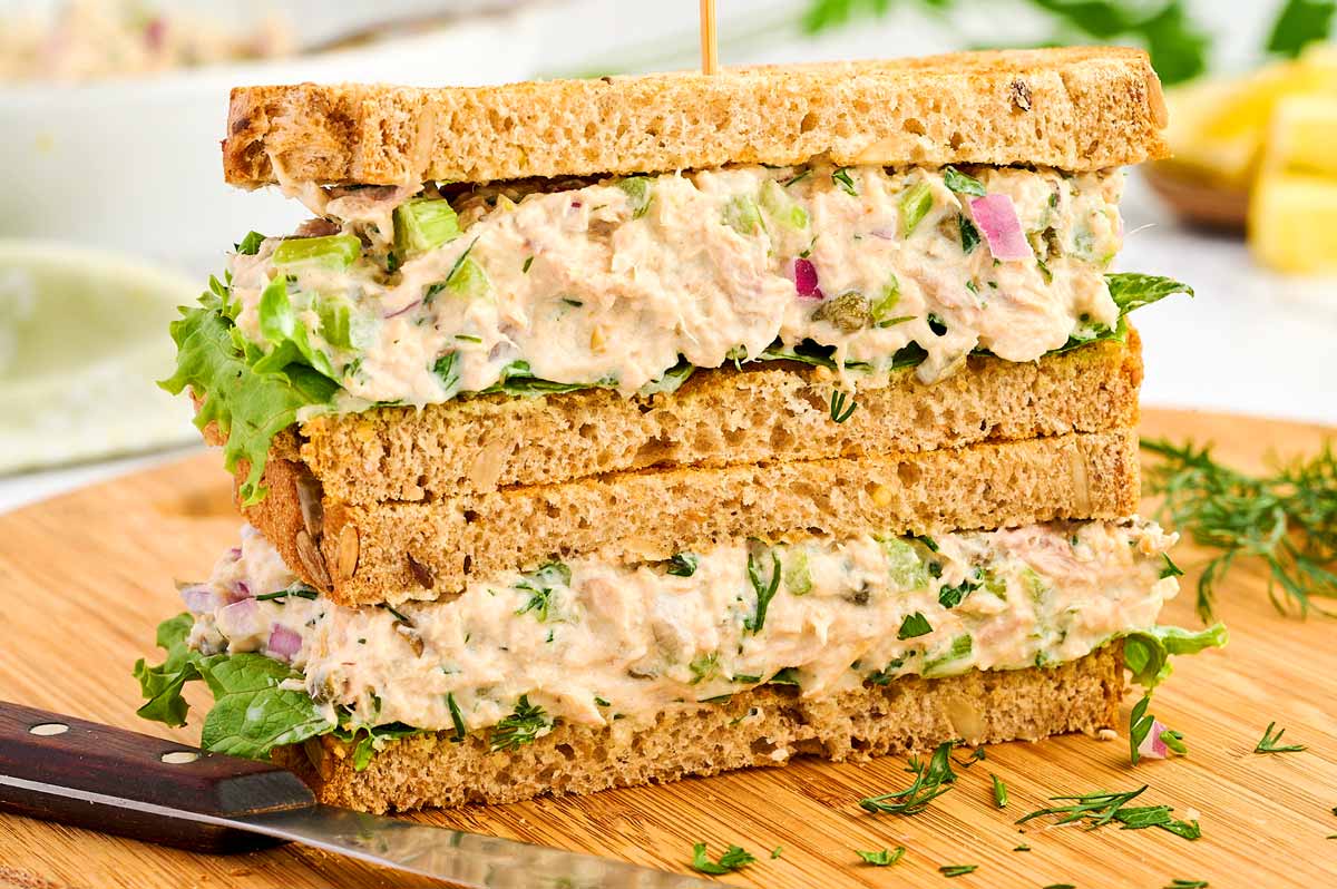 Tuna Salad sandwich stacked on a wooden board.