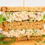 Tuna Salad sandwich stacked on a wooden board.