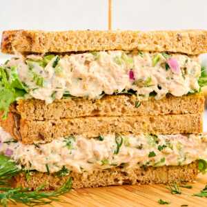 Tuna Salad sandwich stacked on a wooden board.