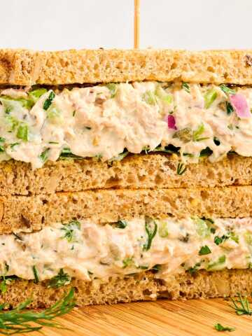 Tuna Salad sandwich stacked on a wooden board.