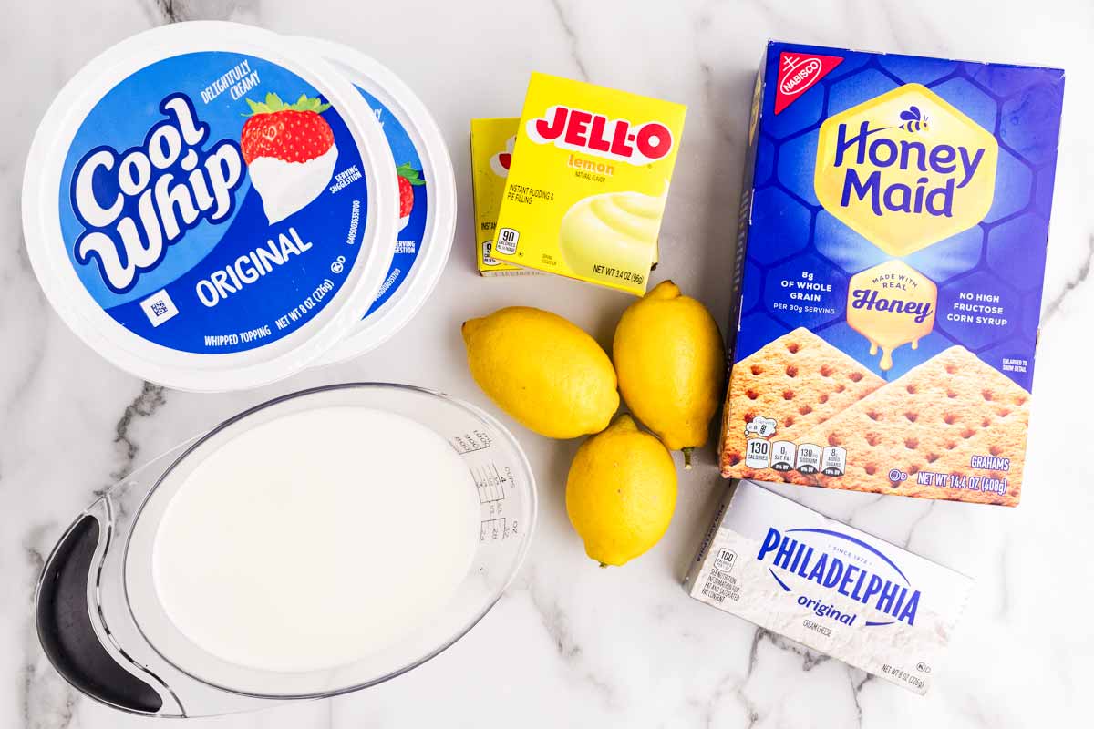 Ingredients for Lemon Icebox Cake on a marble surface.