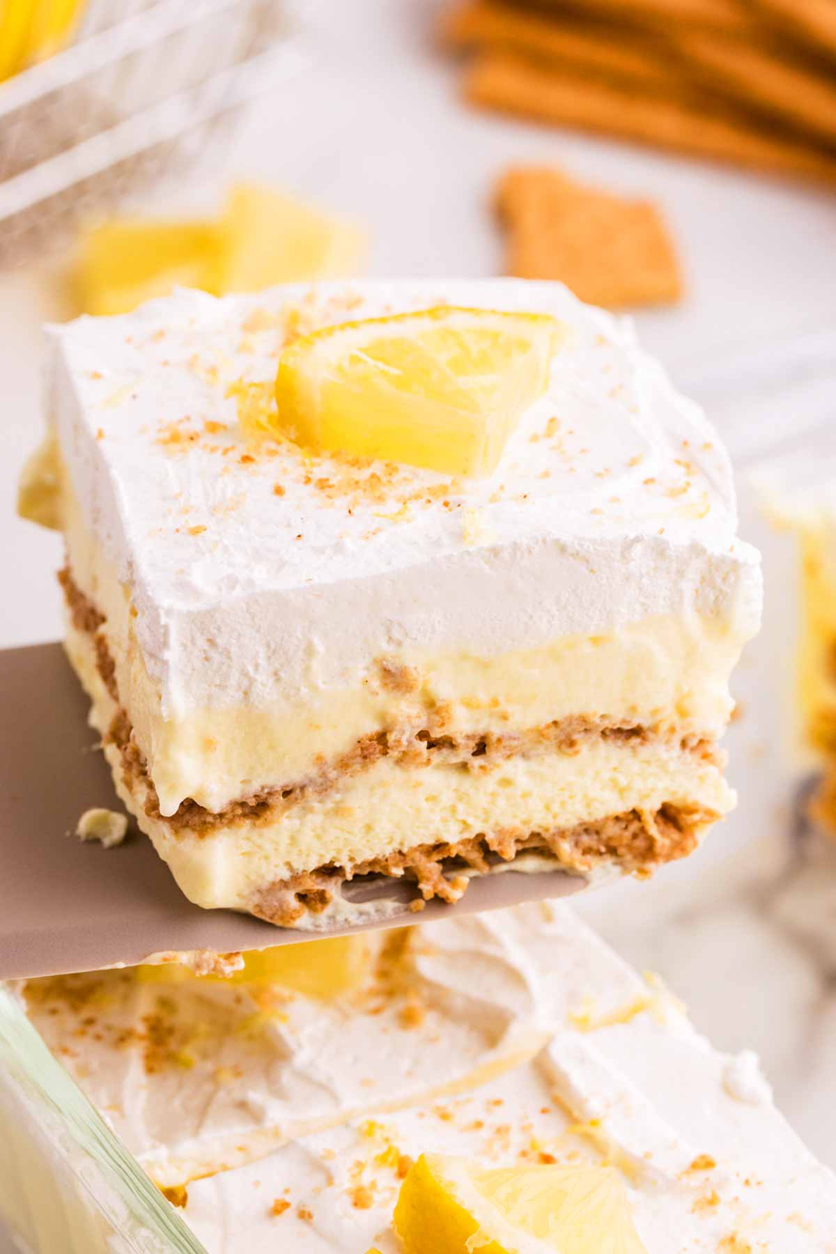 Serving a slice of lemon icebox cake on a cake server.