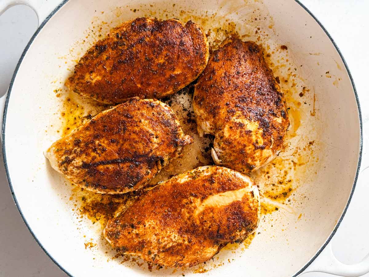 Overhead view of seared chicken breast in skillet.