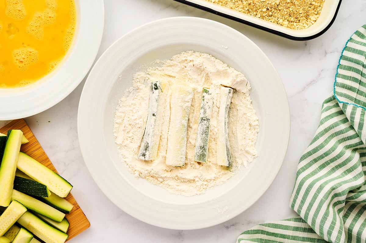 Zucchini sticks in seasoned flour.