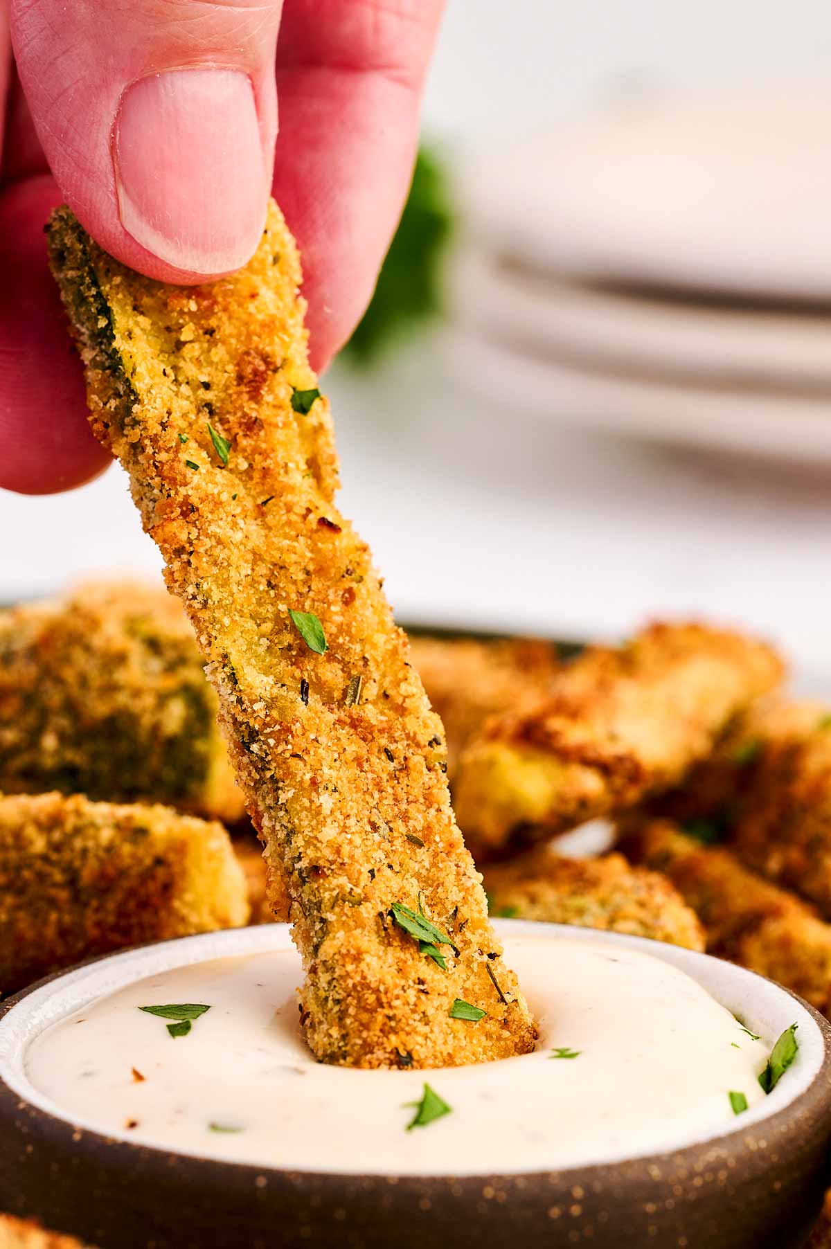 Dipping a zucchini fry in ranch dip.