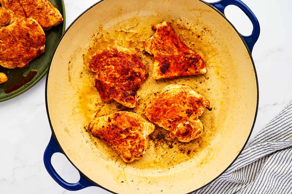 Searing chicken breast in a skillet.