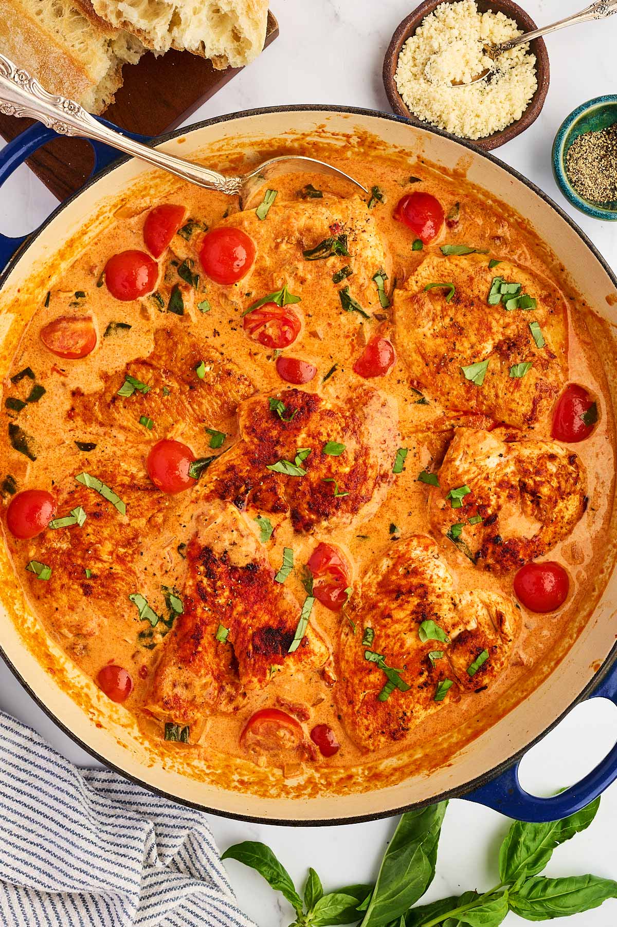 Overhead view of a skillet filled with creamy tomato basil chicken.
