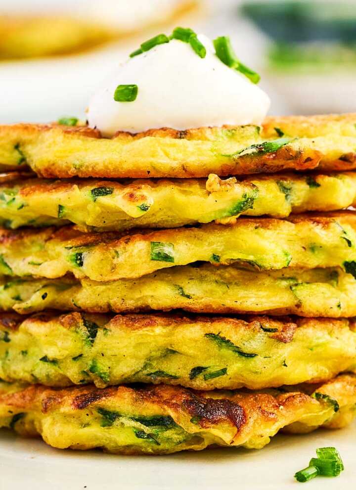 Stack of zucchini fritters on a plate.