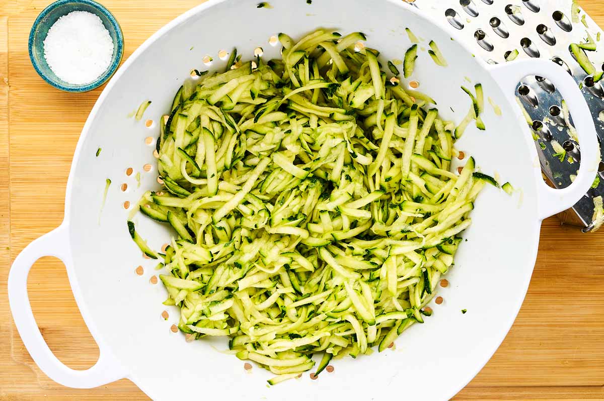 Shredded zucchini in a colander.