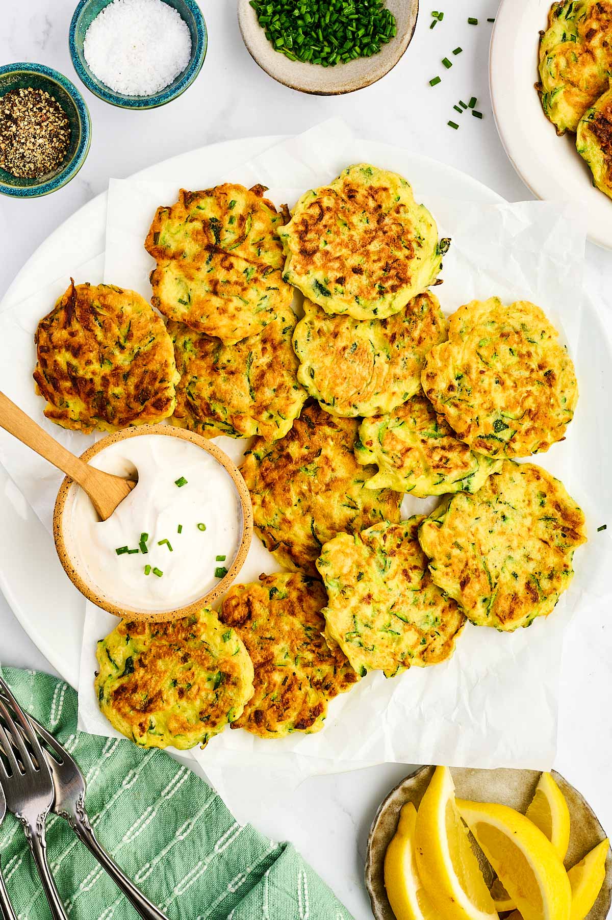 Platter with zucchini fritters and sour cream.