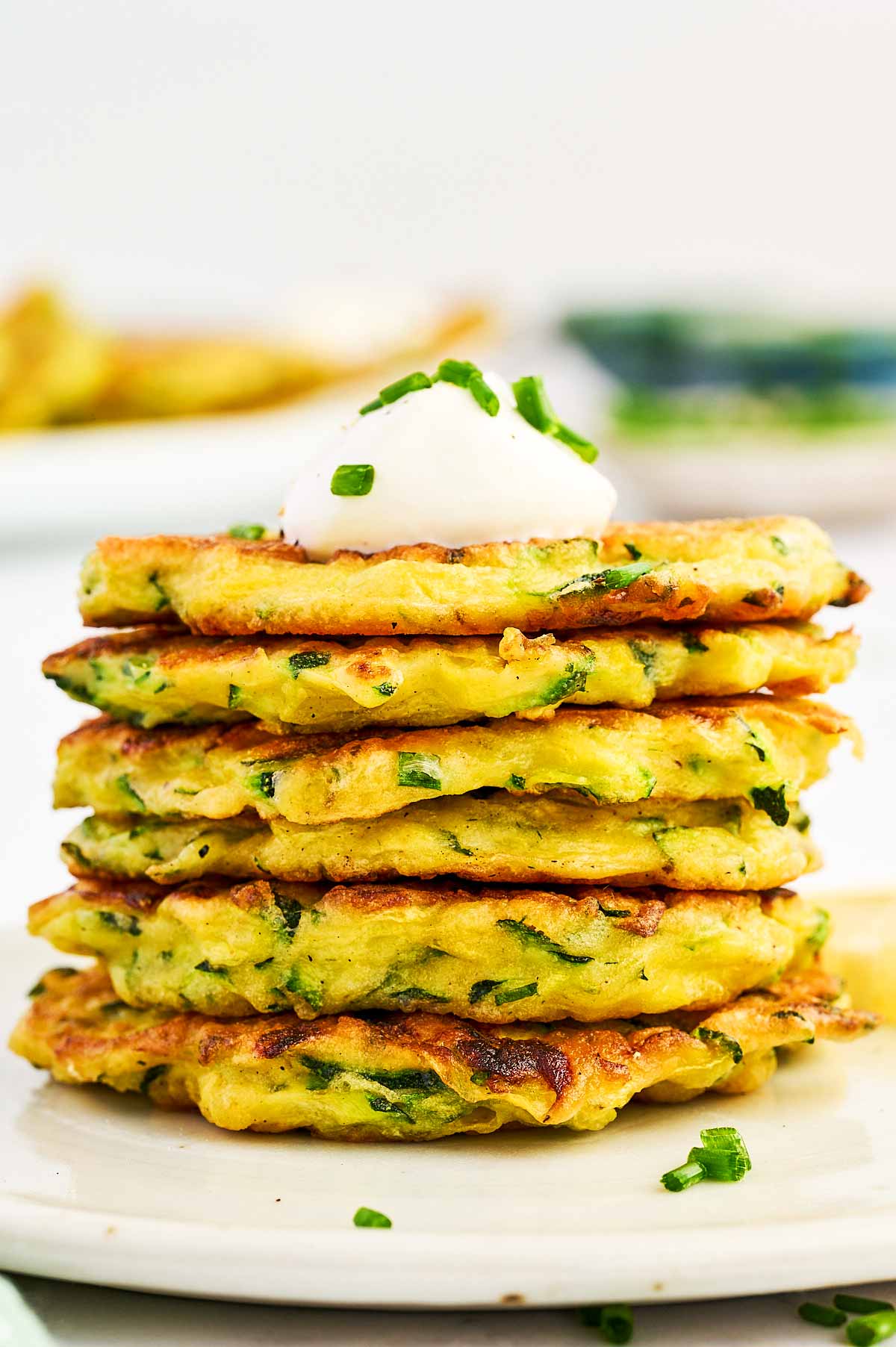 Stack of zucchini fritters on a plate.