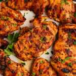 Platter with grilled chicken thighs and parsley.