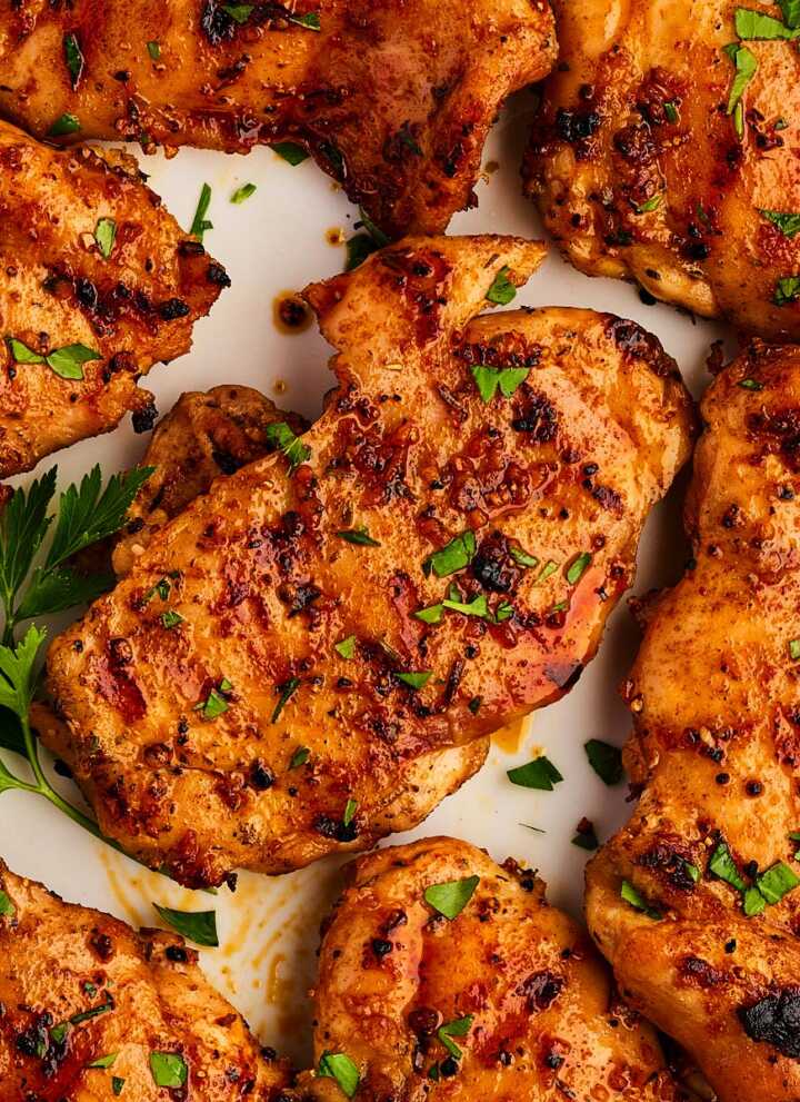 Platter with grilled chicken thighs and parsley.