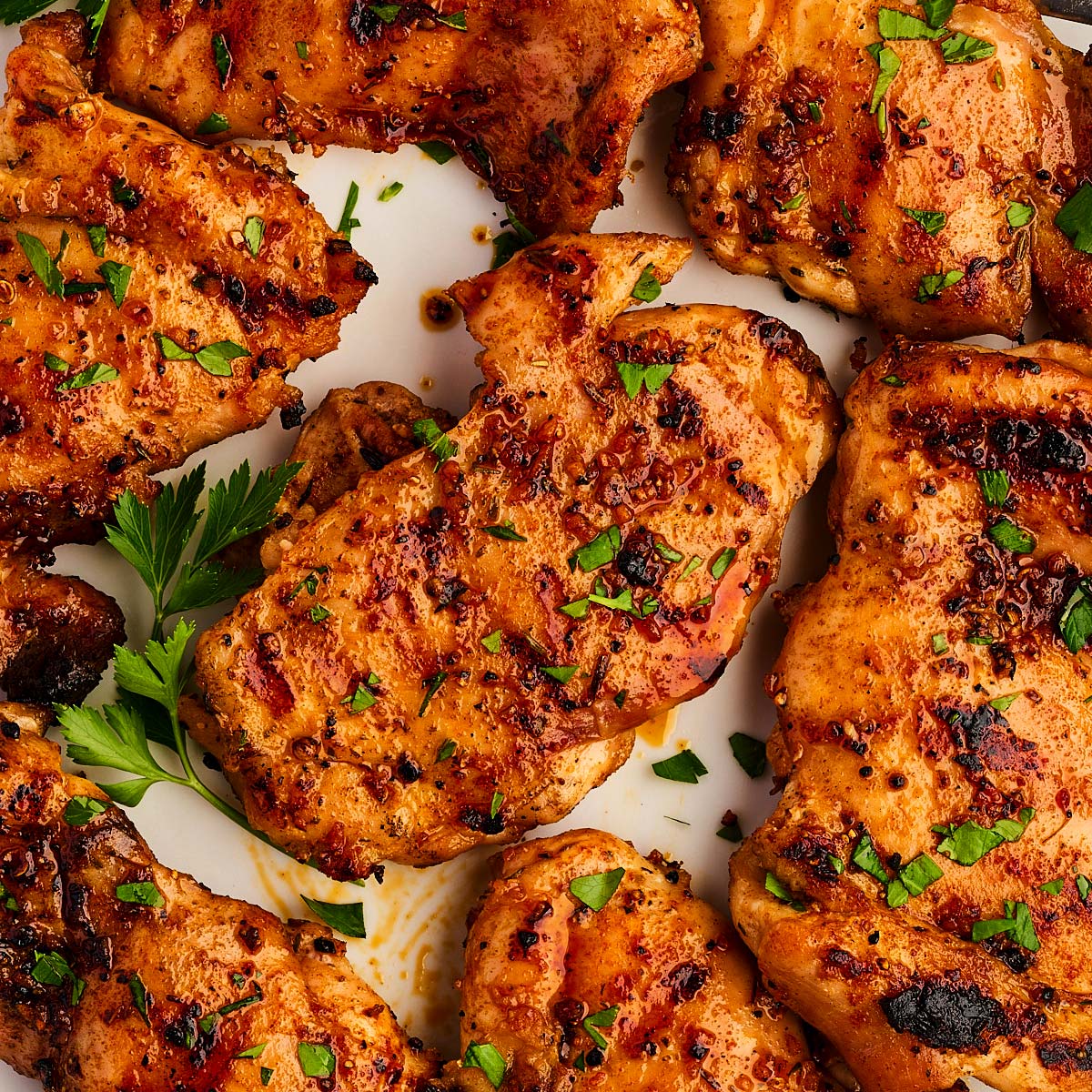 Platter with grilled chicken thighs and parsley.