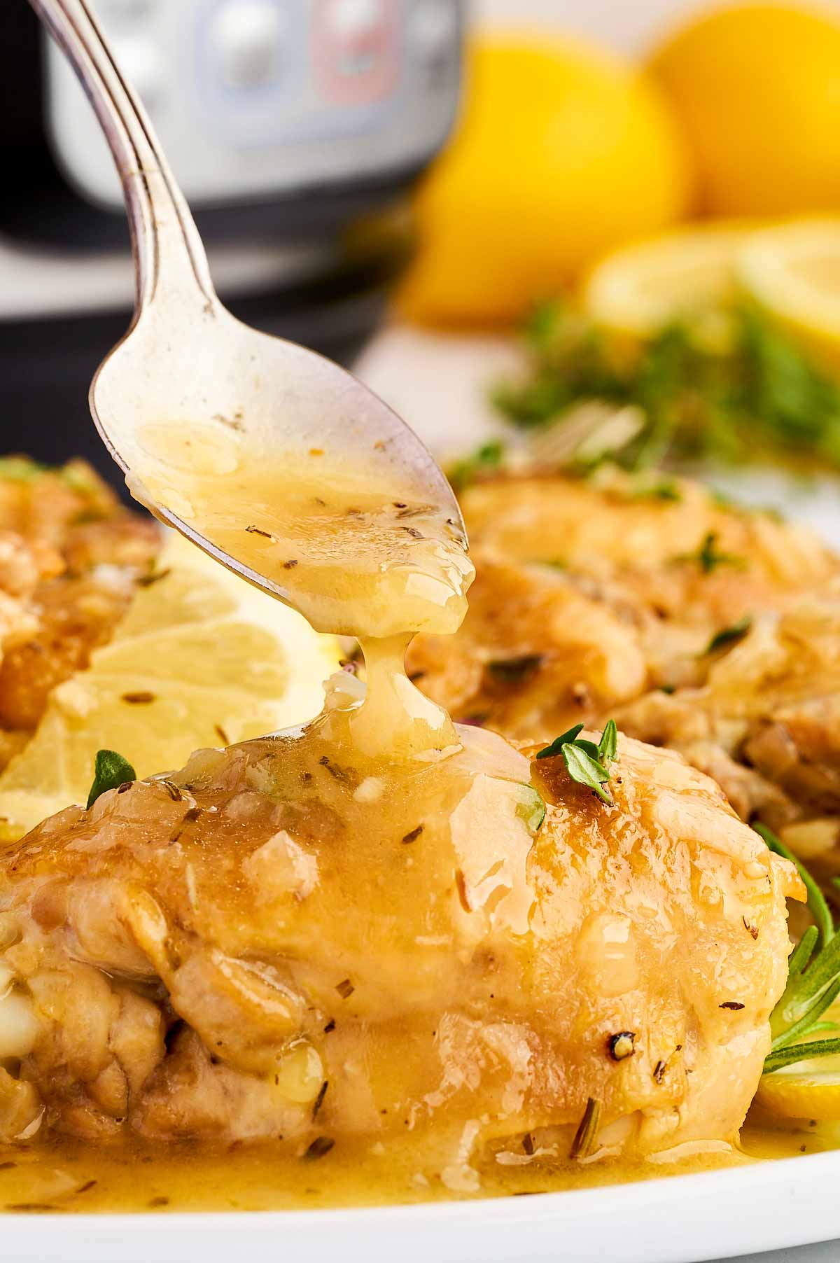 Drizzling sauce over a lemon chicken thigh.